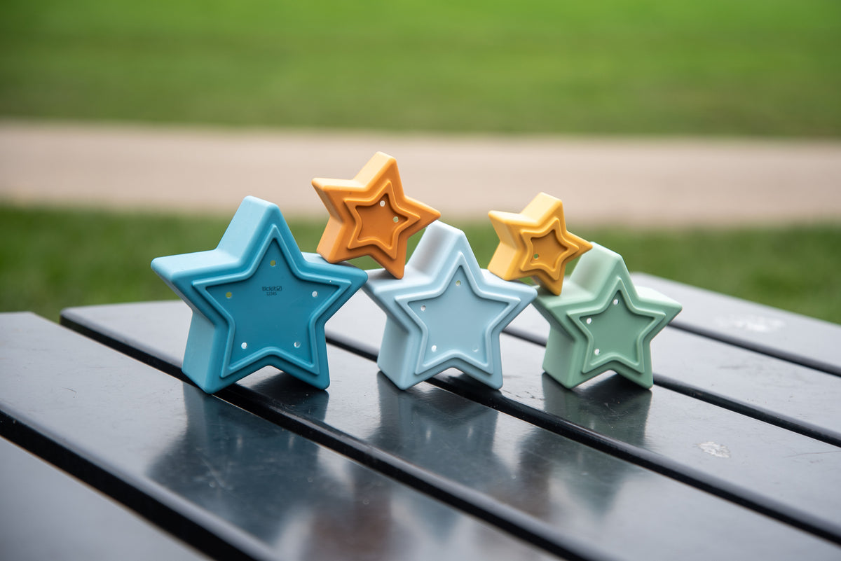 Row of star-shaped stacking cups in blue, light green, and orange