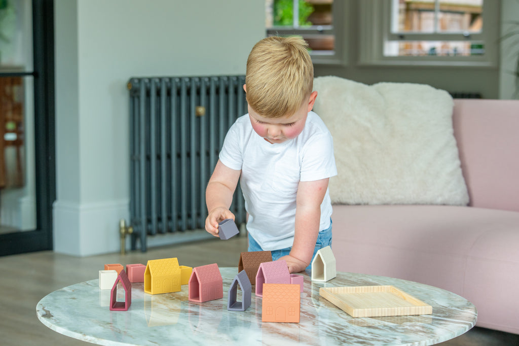 House-shaped silicone blocks set with wooden base tray on a marble table