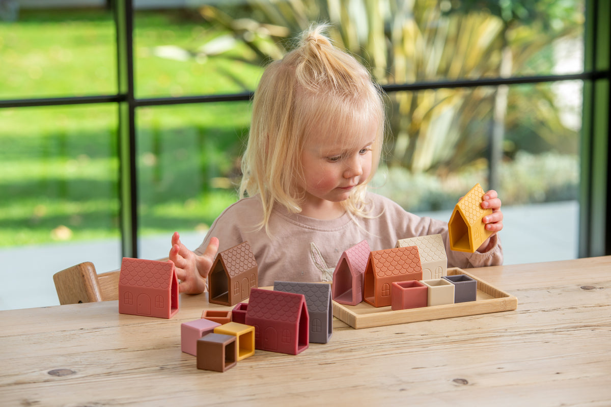 Village block set with house-shaped silicone pieces on wooden tray in front view