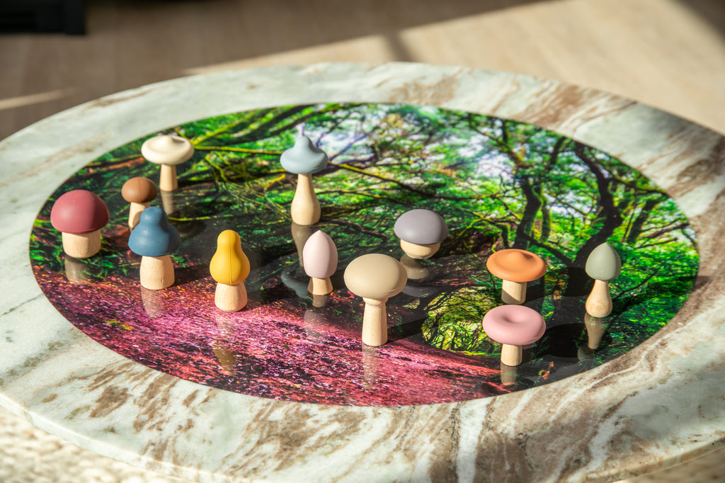 Colorful wooden mushroom stacking pieces arranged on a round woodland play mat