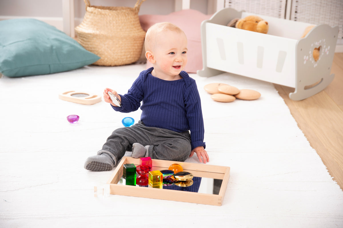 Small wooden mirror tray with mirrored base and shiny toy balls and blocks