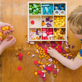 Wooden sorting tray filled with multicolor foam pieces
