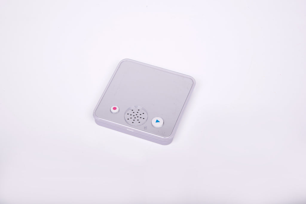 Small gray sound-and-mirror device with speaker grille, lights, and play button