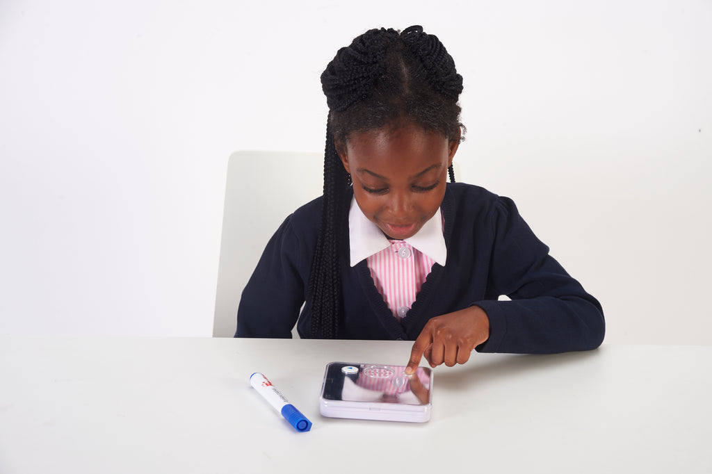 Children's sound-and-mirror learning device on a table as a child points to the screen
