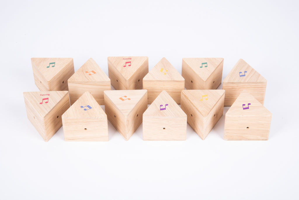 Row of wooden sound prism blocks with colorful musical note decals, natural finish
