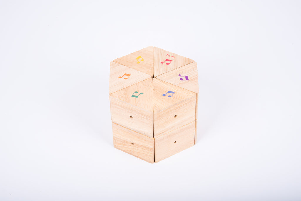 Wooden sound prism cube with musical note decals on natural wood faces