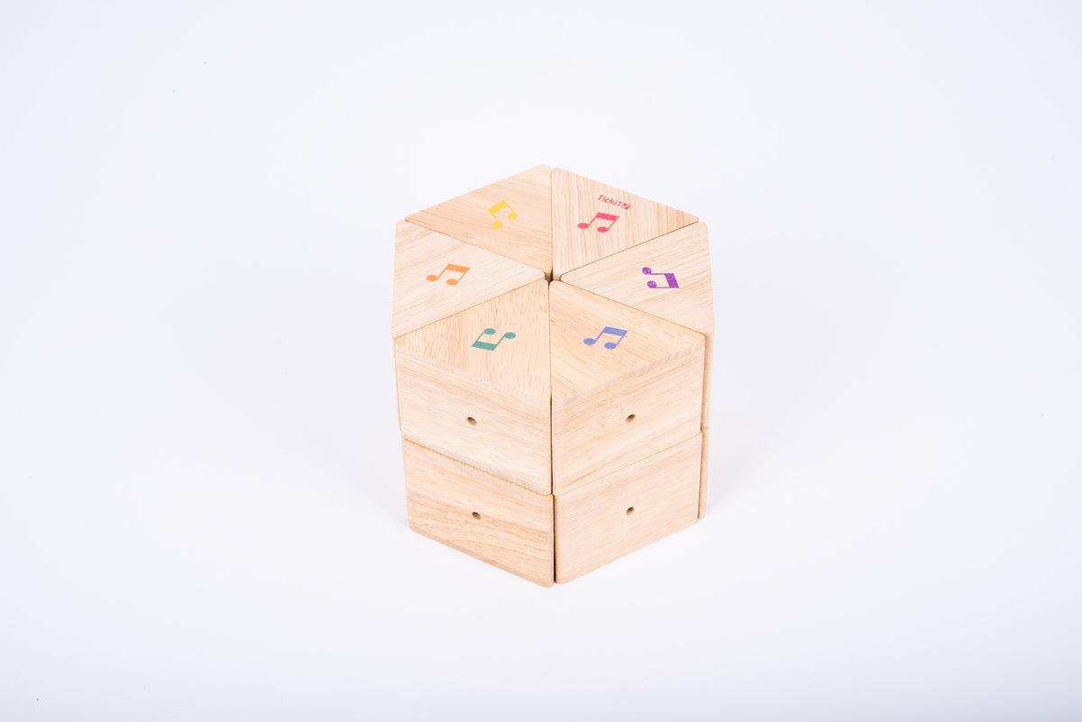 Wooden sound prism cube with musical note decals on natural wood faces