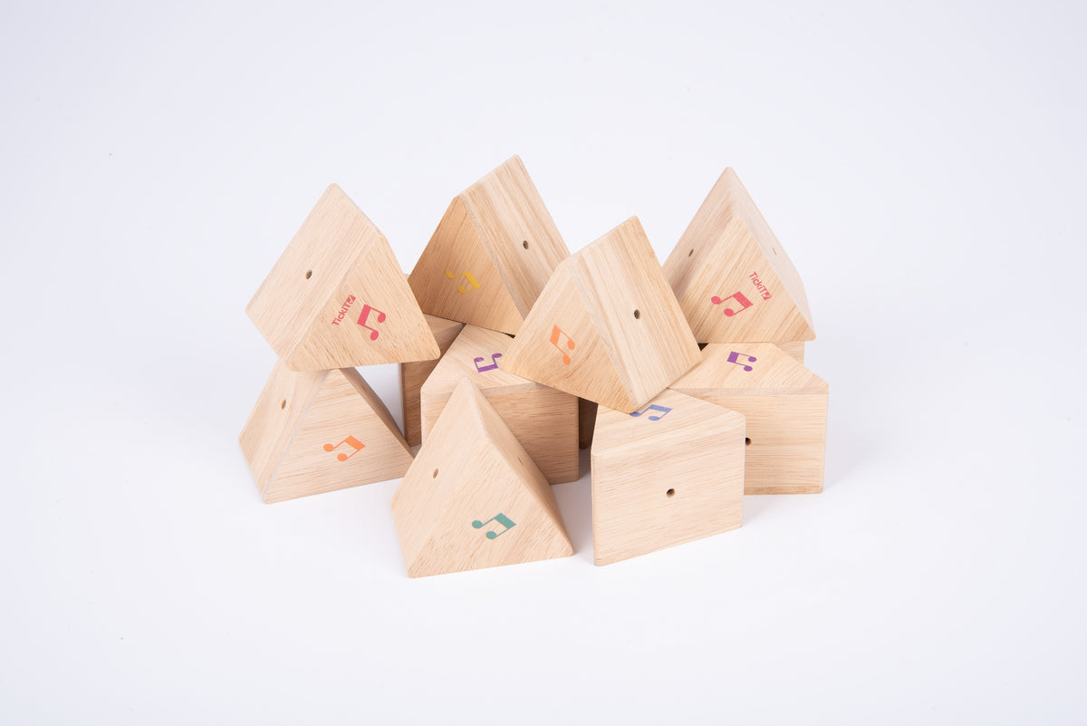 Wooden triangular sound prism blocks with colorful musical note decals in a heap