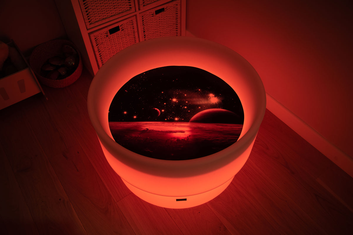 Round space play mat with red glowing LED border and planet scene