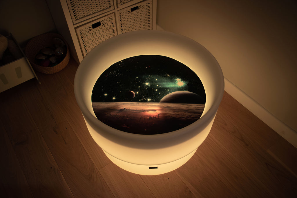 Round space play mat with warm yellow glowing LED border and planet scene