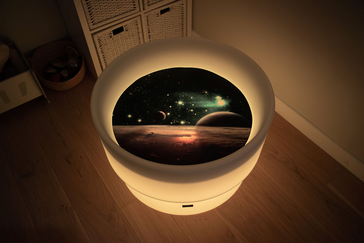 Round space play mat with warm yellow glowing LED border and planet scene