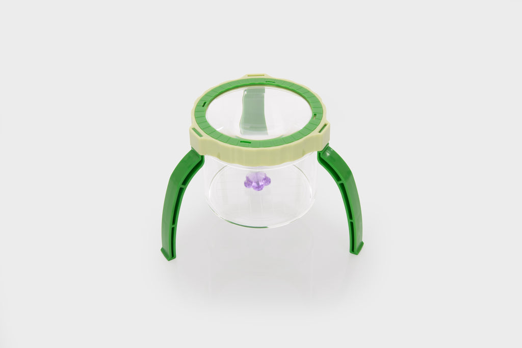 Green tabletop magnifier with clear glass lens and raised stand