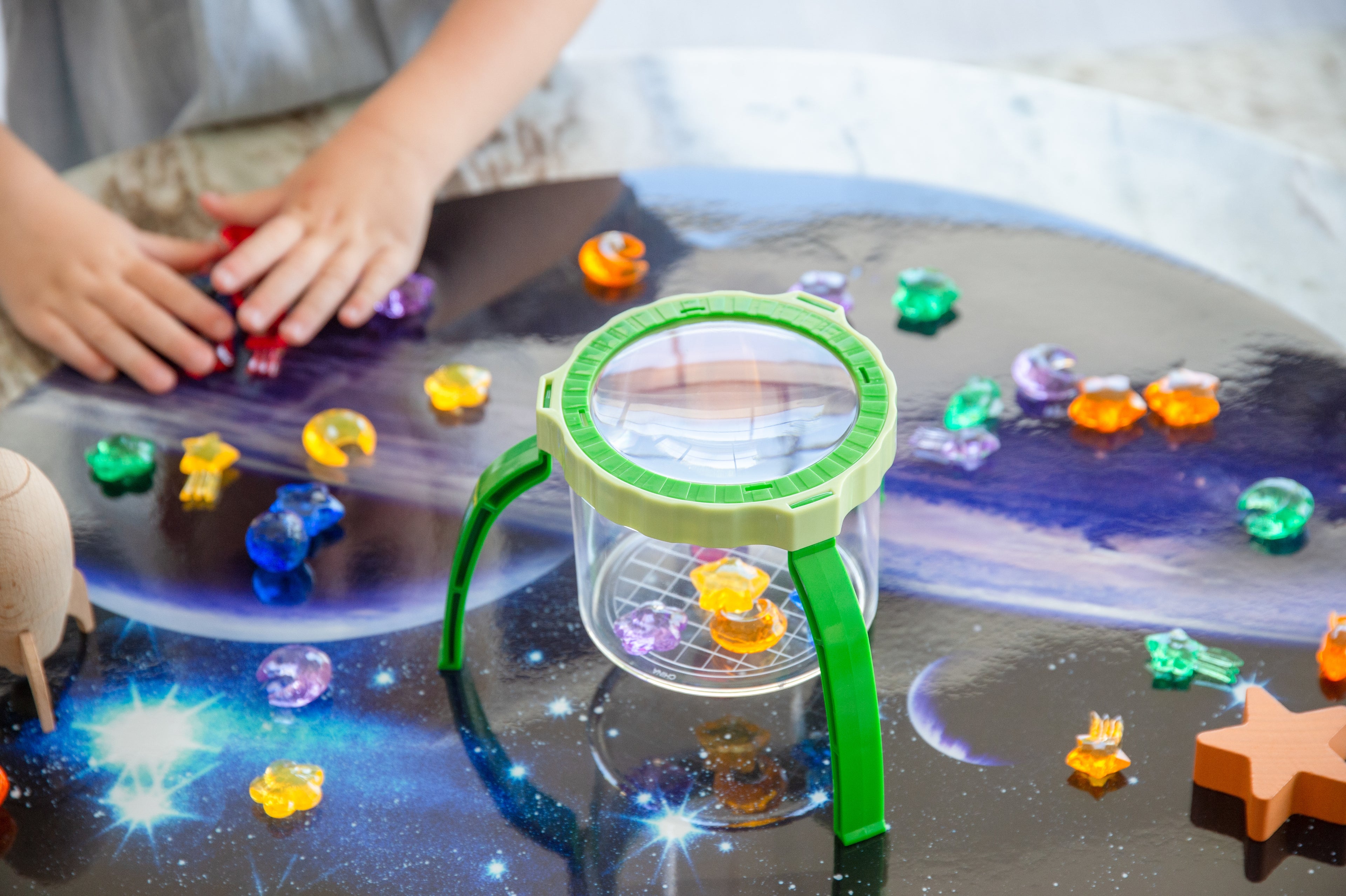 Green tabletop magnifier with clear magnifying cup and circular lens window