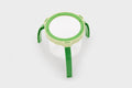 Green tabletop magnifier with circular lens frame and tripod-style legs