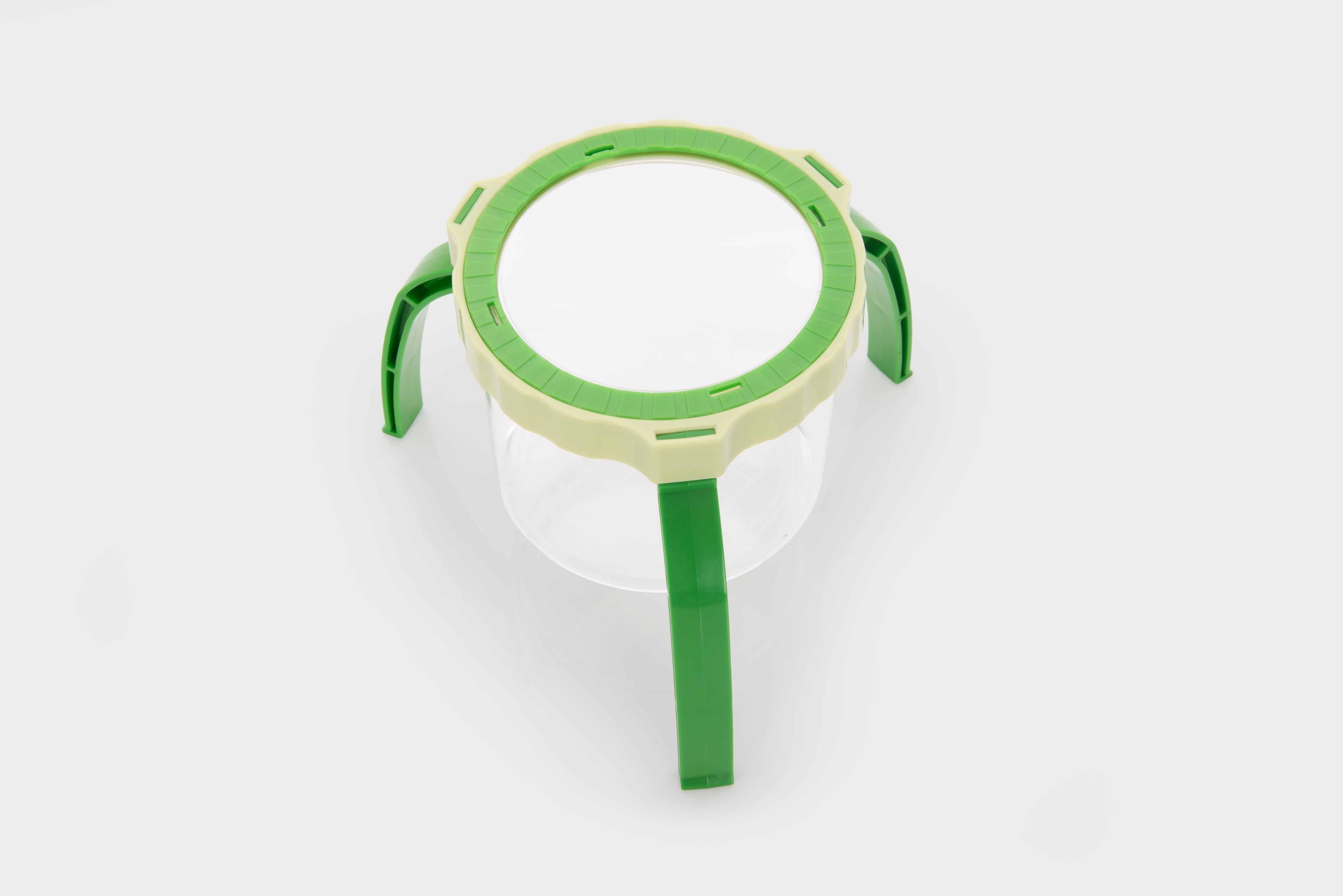 Green tabletop magnifier with circular lens frame and tripod-style legs
