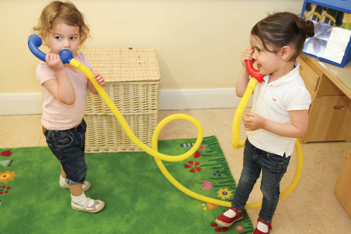 Children playing with yellow talking tubes, blue and red end mouthpieces