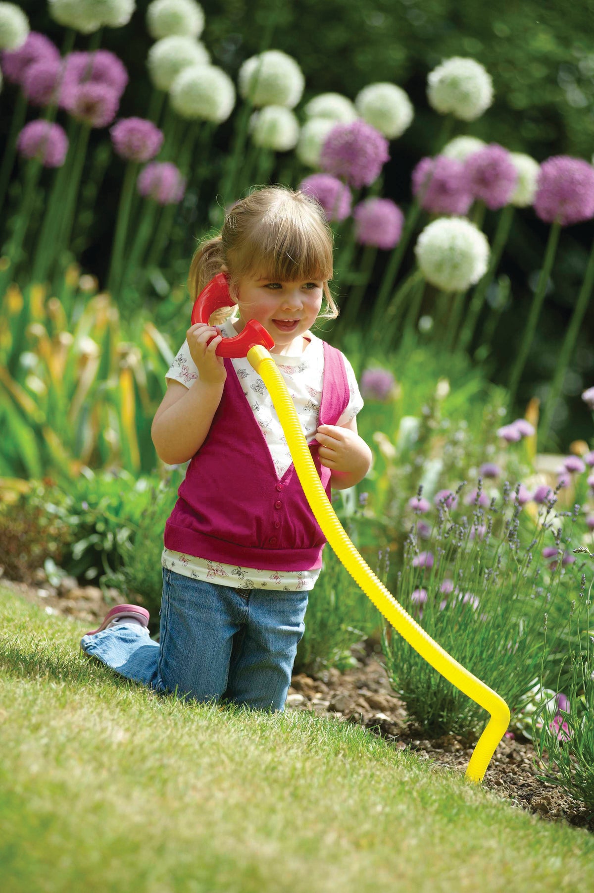 Young child holding a yellow talking tube with red and blue end mouthpieces