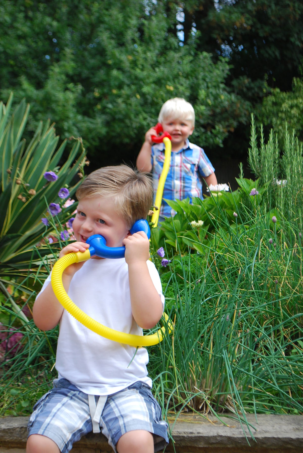 Child using a yellow talking tube with a blue mouthpiece end