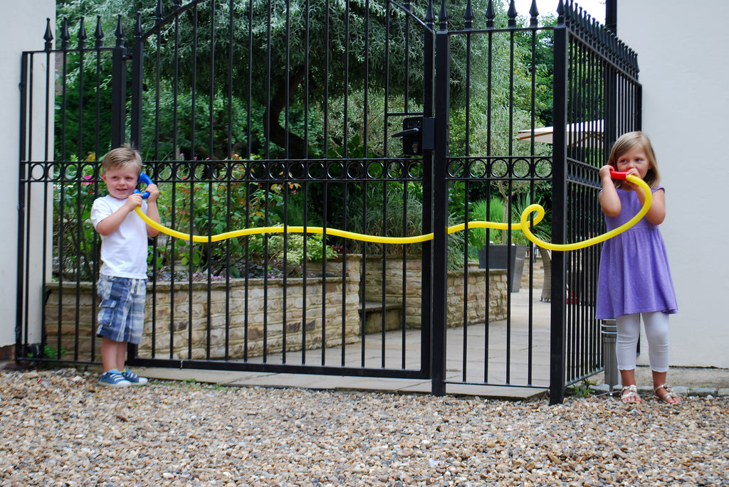 Two children holding yellow talking tubes with blue and orange end mouthpieces