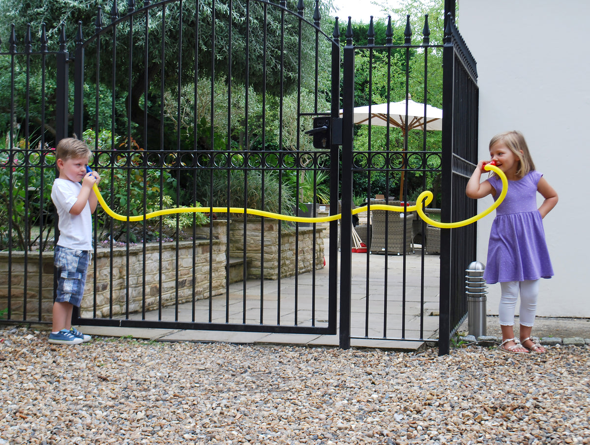 Children holding yellow talking tubes with blue and orange end mouthpieces