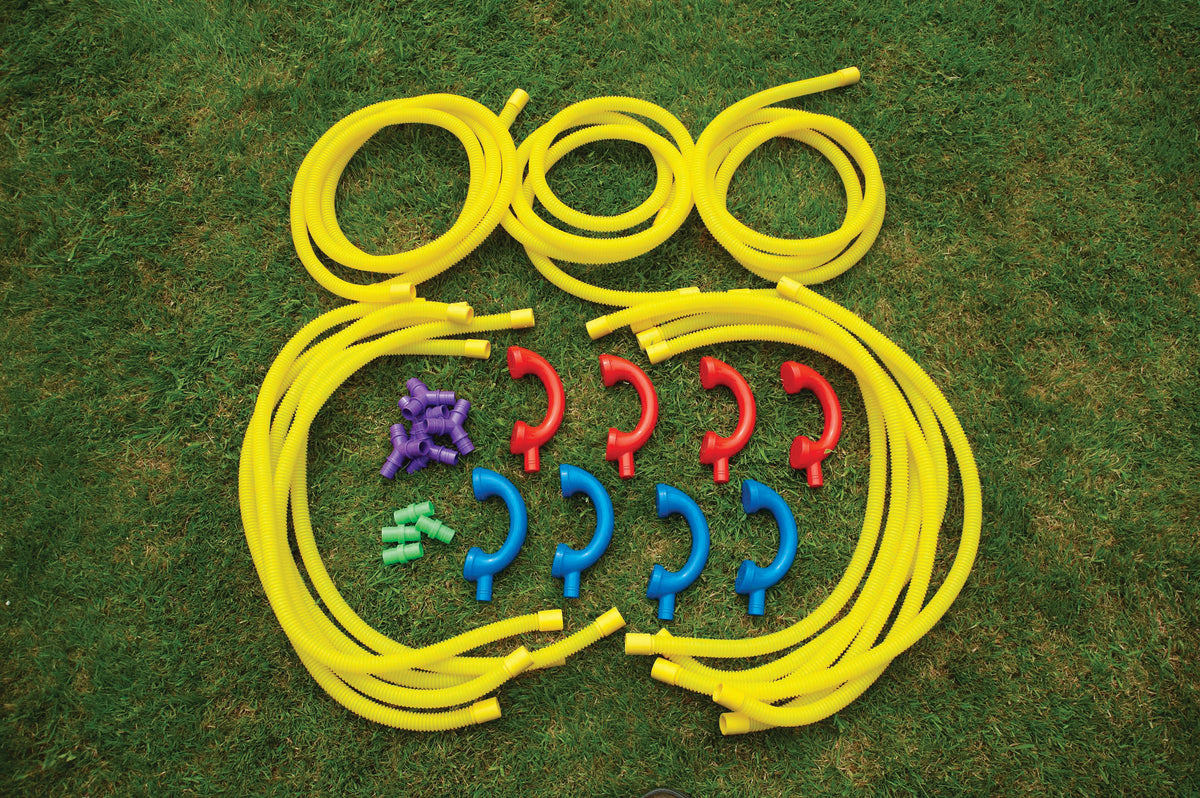 Yellow coiled tubes with colorful connector pieces and red hooks on grass