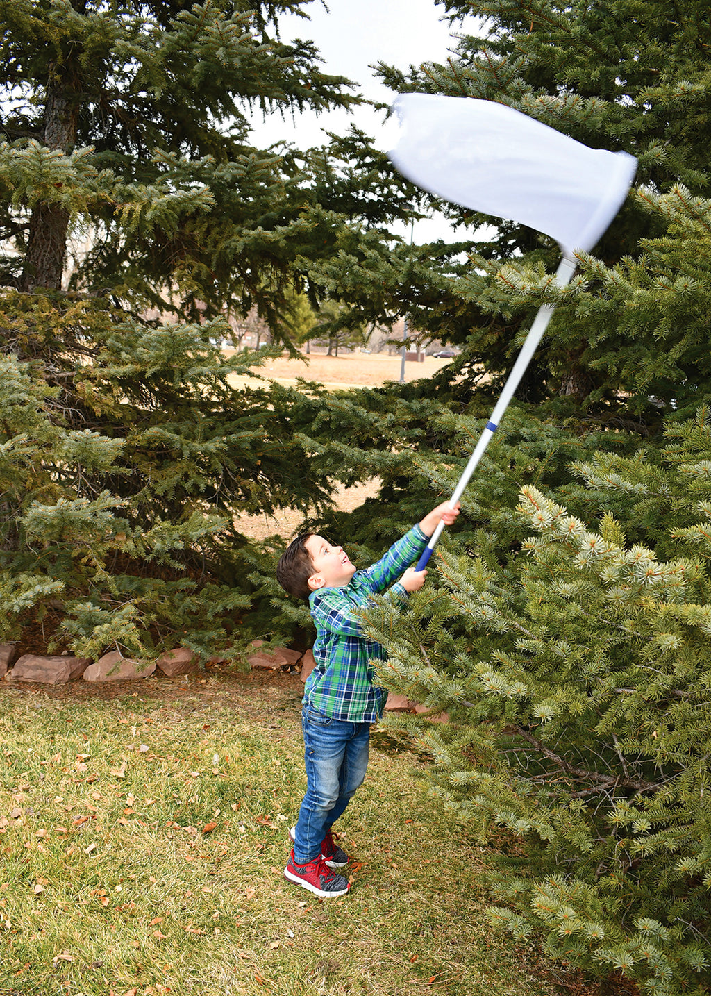 Telescopic sweep net with white mesh bag and long white handle, extended outdoors