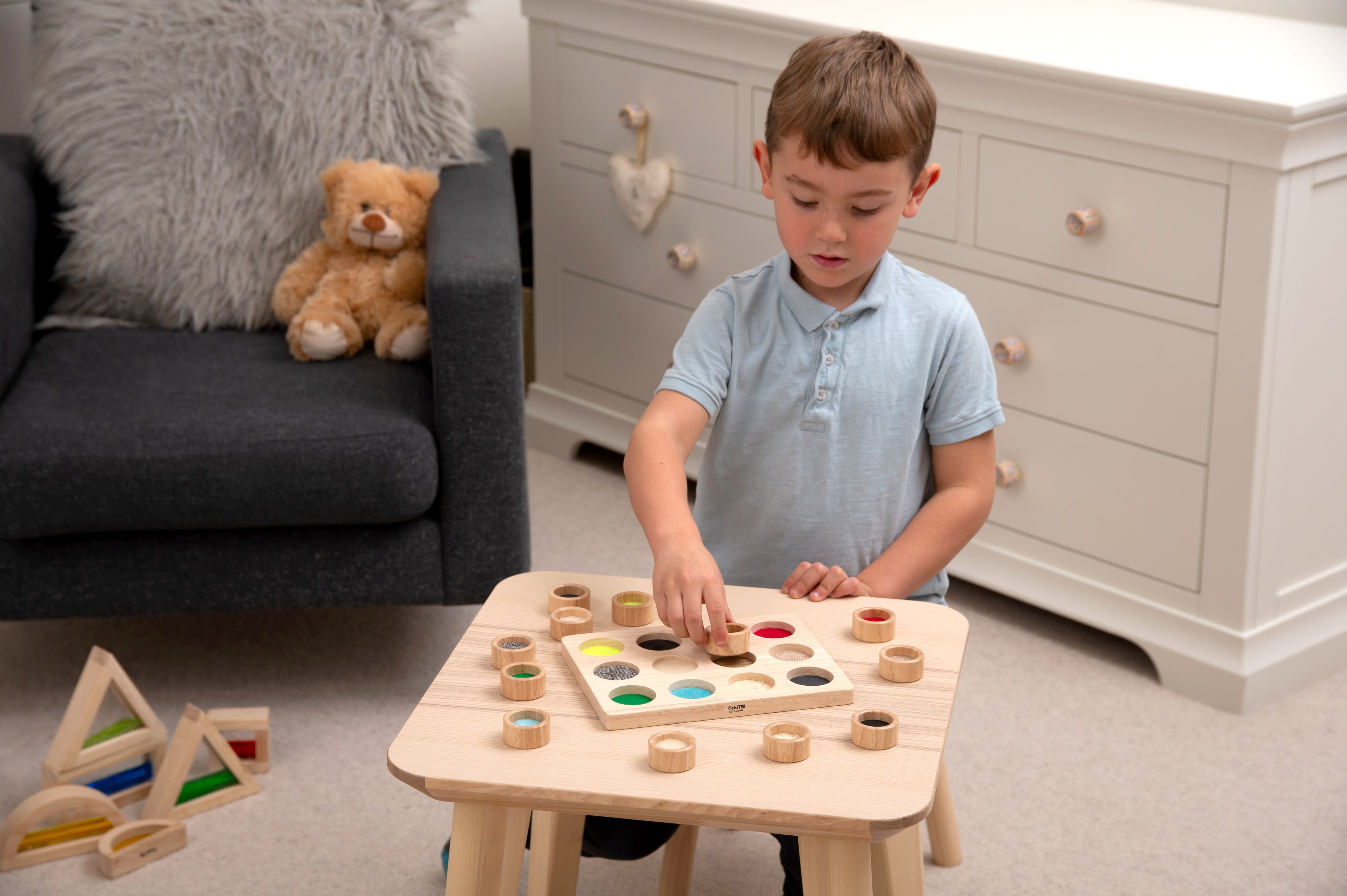 Wooden touch-and-match board with colorful pegs and circular matching holes