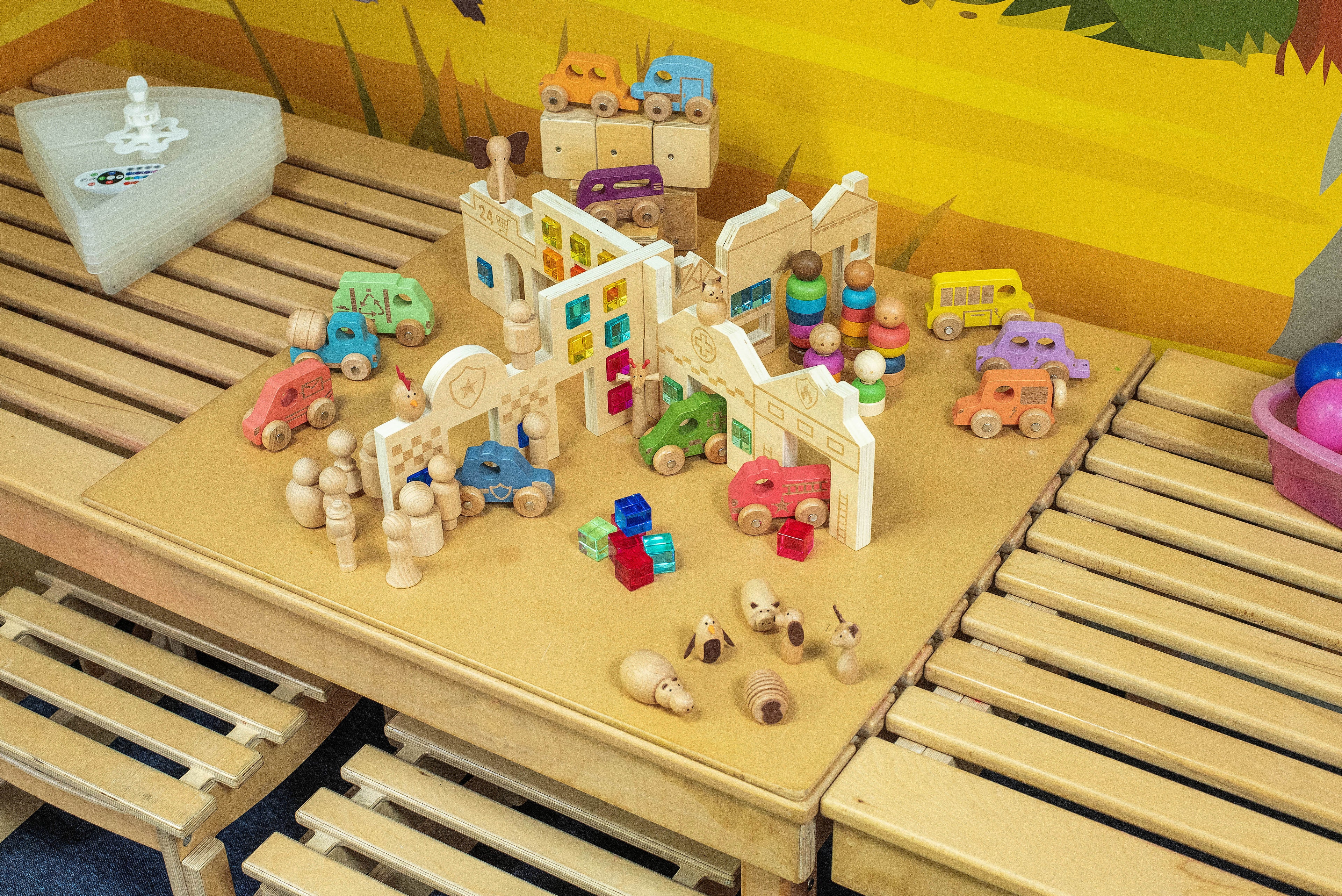 Wooden toy town playset with colorful vehicles, figures, and building blocks