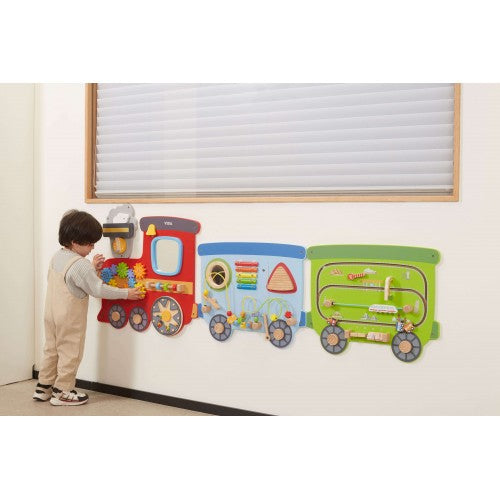 Train wall panel set with three colored train cars mounted on wall, near child playing