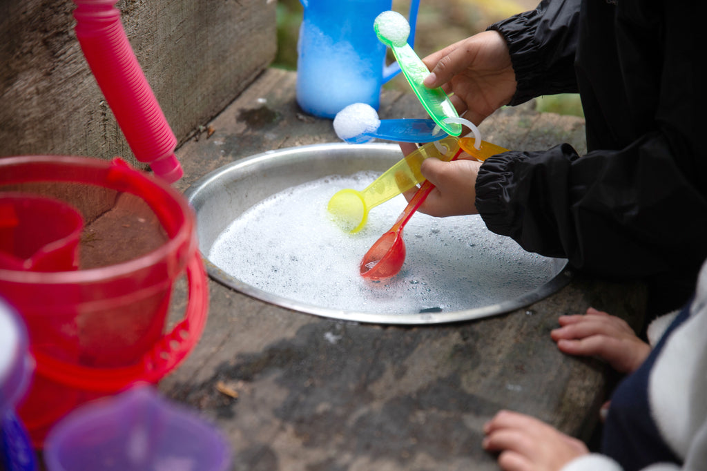 Translucent measuring spoons being used to scoop ingredients into a bowl.