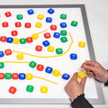Translucent number lacing beads with colorful numbered tiles and yellow cord, hands threading