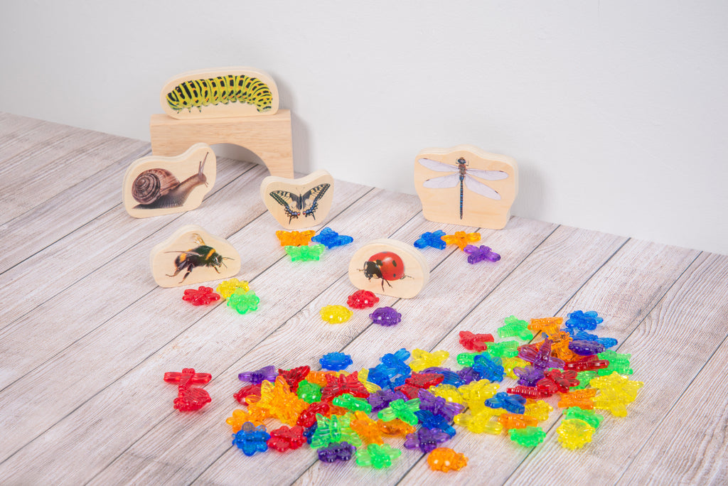 Translucent colorful bug pieces with wooden bug-shape boards and small sample pieces.
