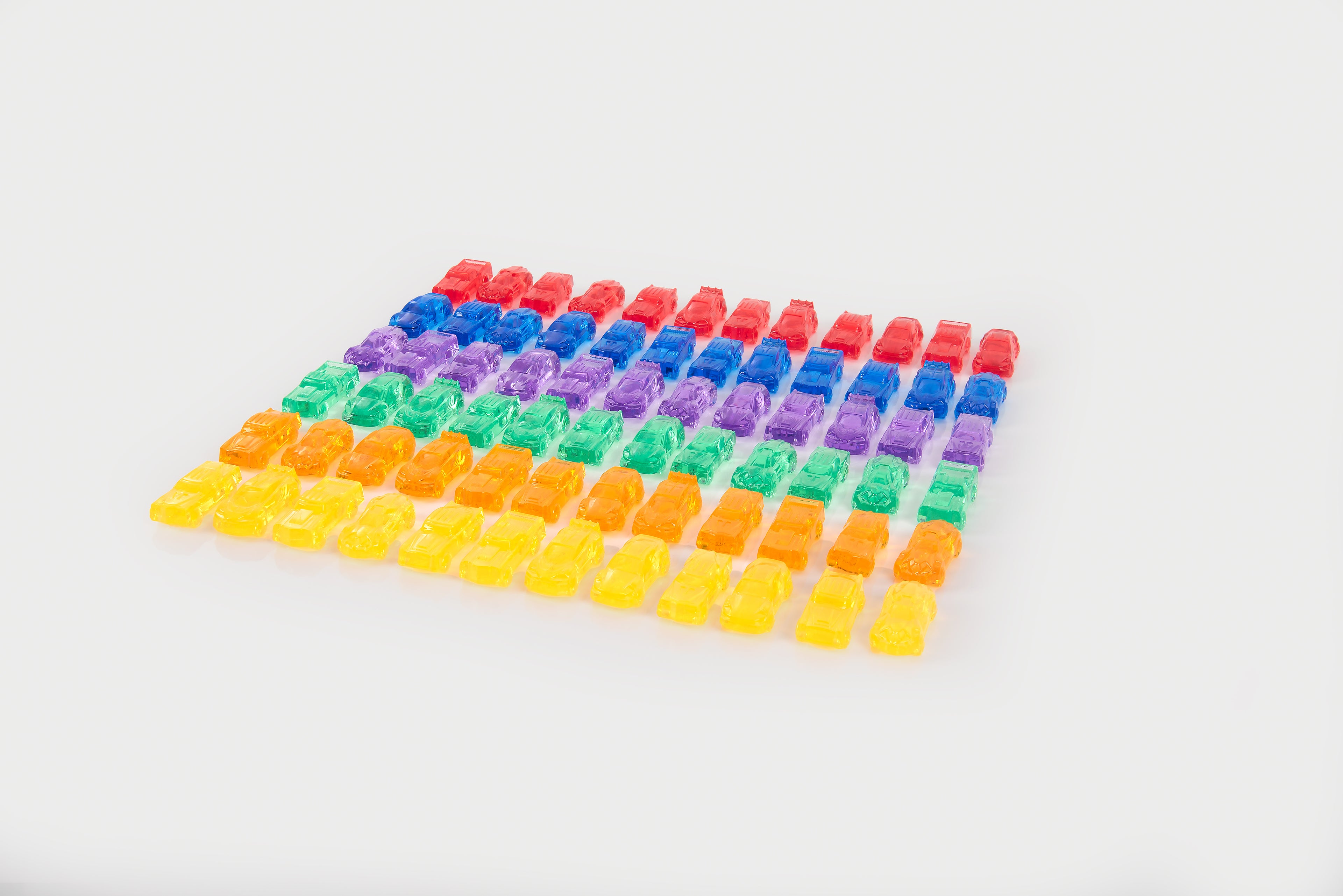 Translucent toy car grid with rainbow rows of small plastic cars