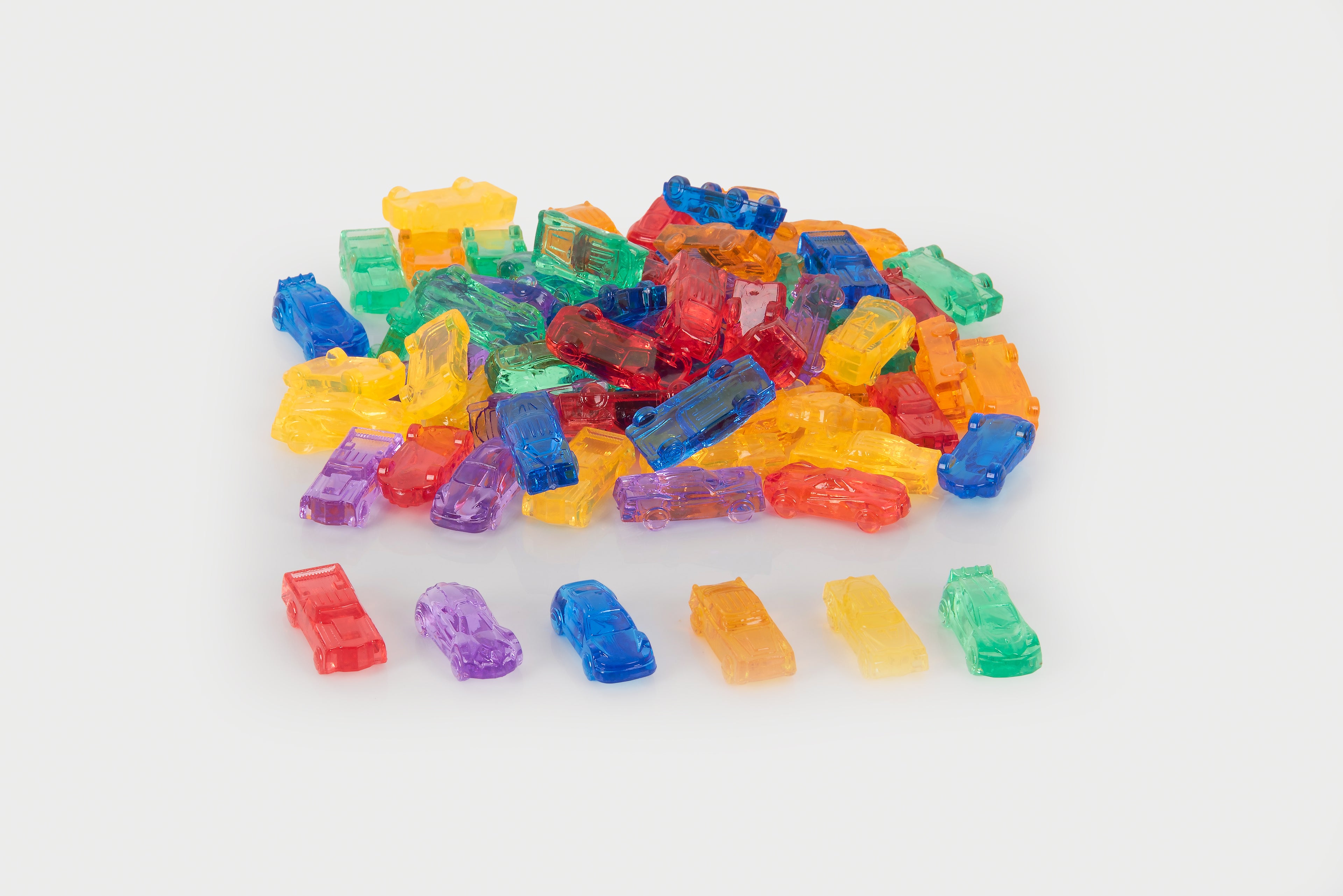 Mixed pile of translucent toy cars in multiple colors with a few loose cars