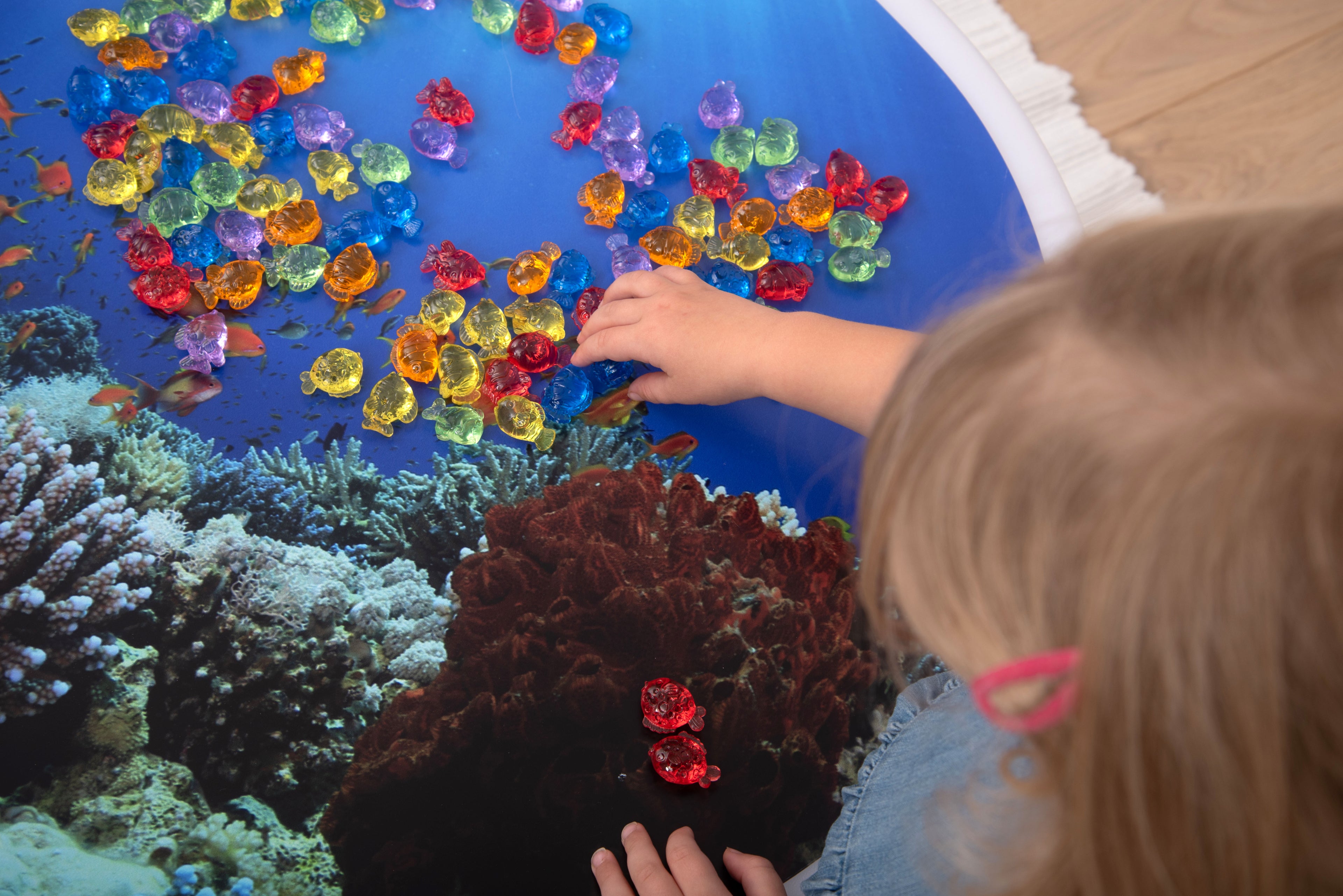 Translucent color fish set: colorful translucent fish on a blue play surface