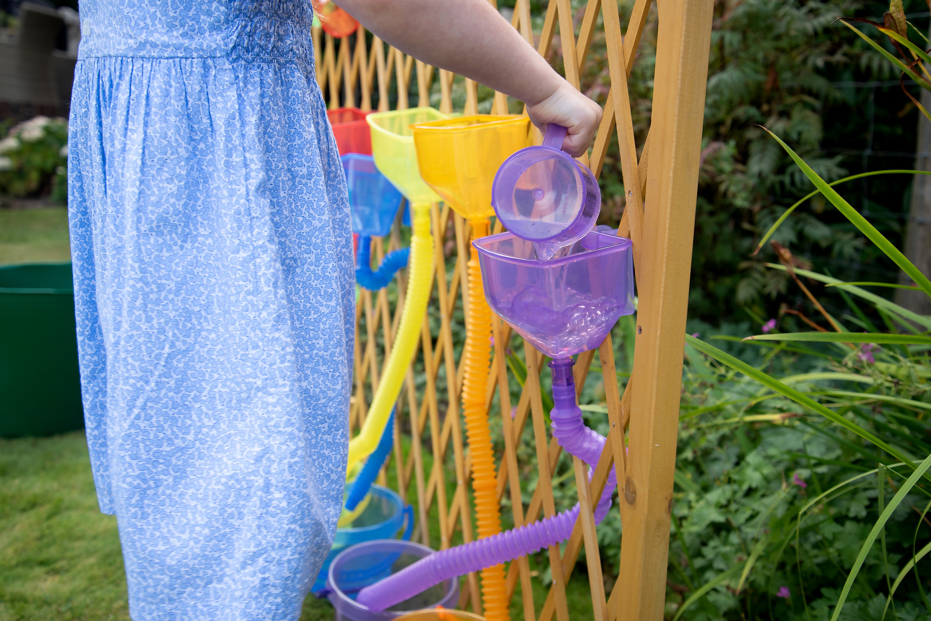 Translucent color funnel set with purple funnel and cup hanging on a wooden frame
