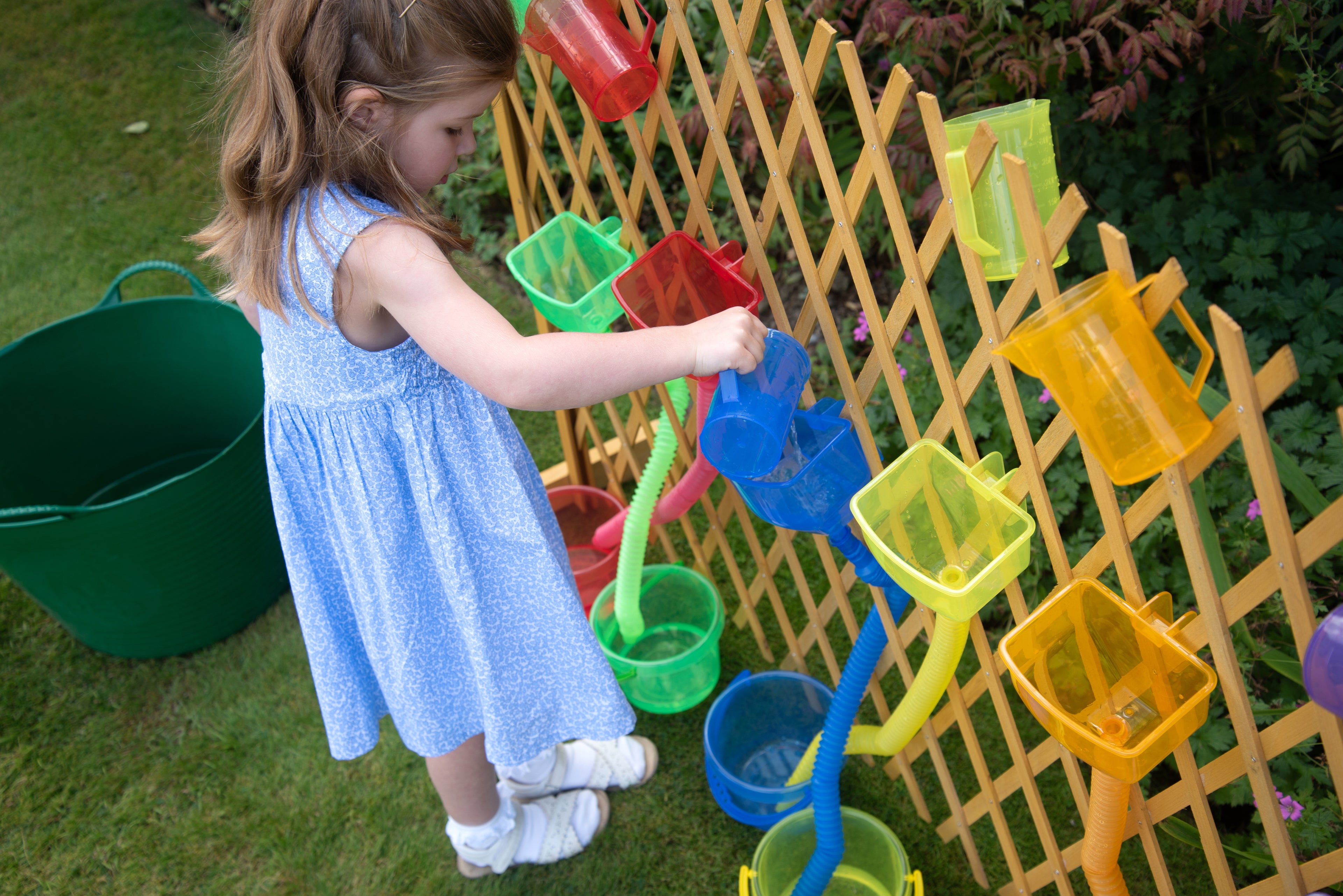 Translucent color funnel set with green and yellow funnels hanging on a wooden grid