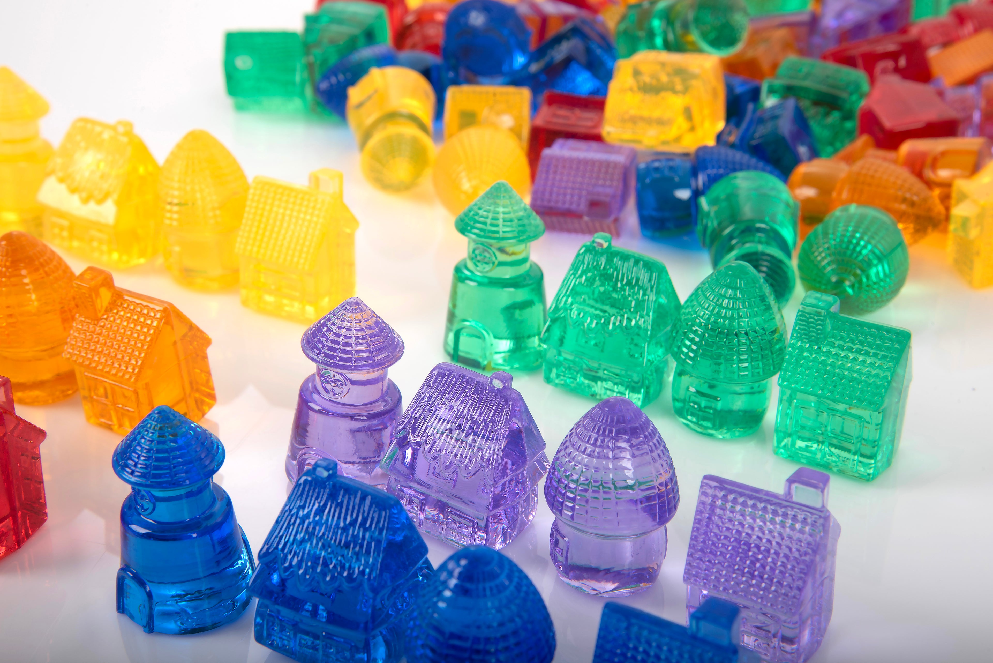 Close-up of translucent colorful toy houses and caps in blue, green, purple, yellow