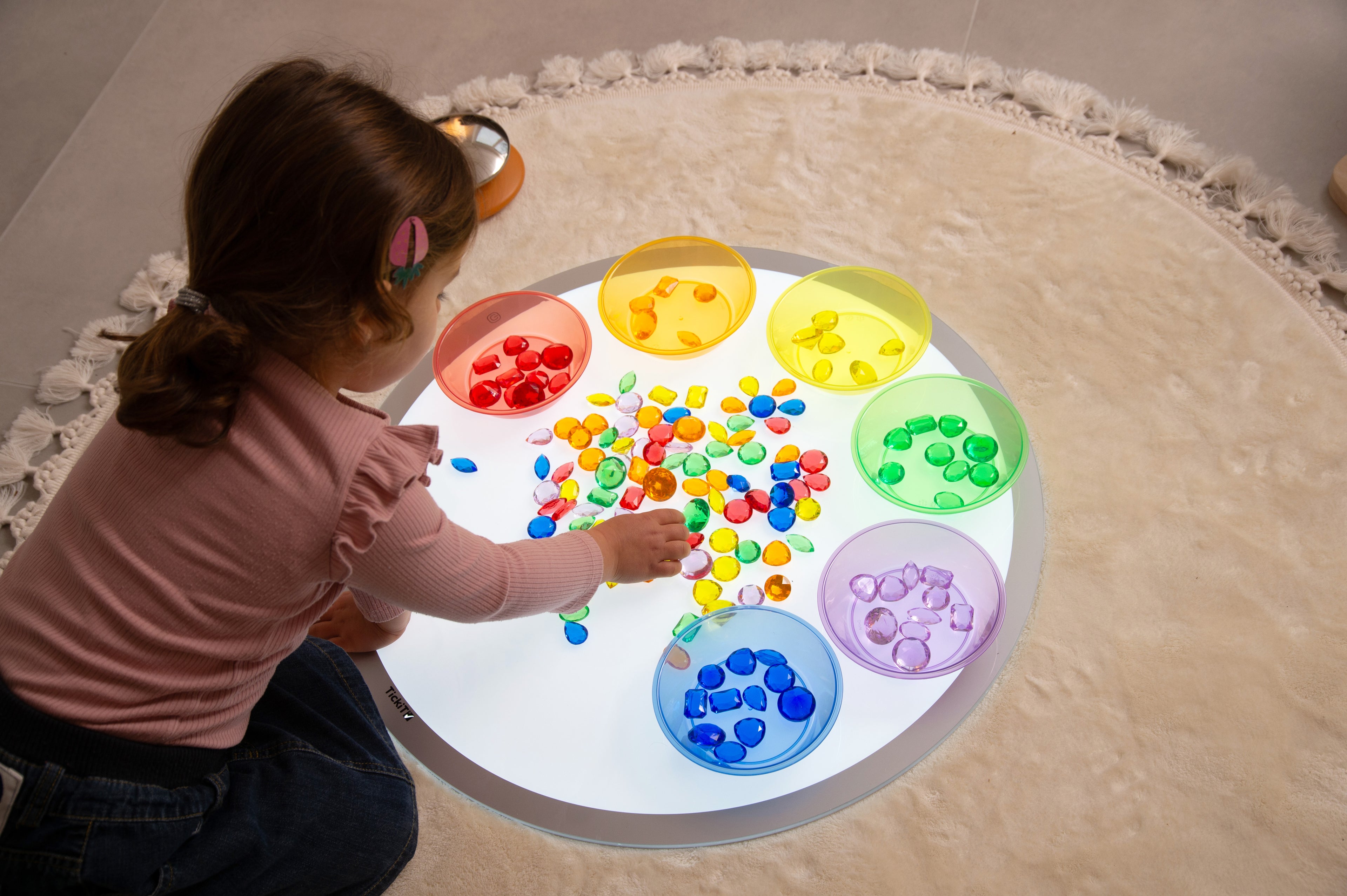 Translucent jewel gems in circular tray with mixed multicolor pieces and colored wells