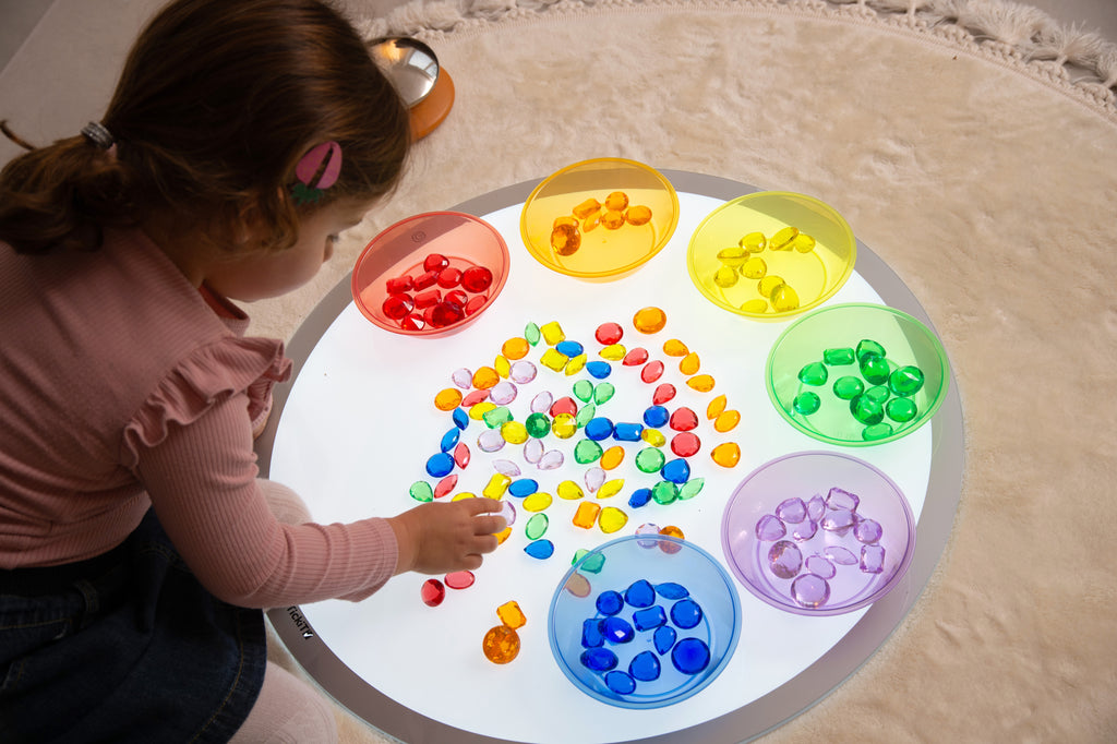 Translucent colored jewel gems in round tray, with multicolor pieces