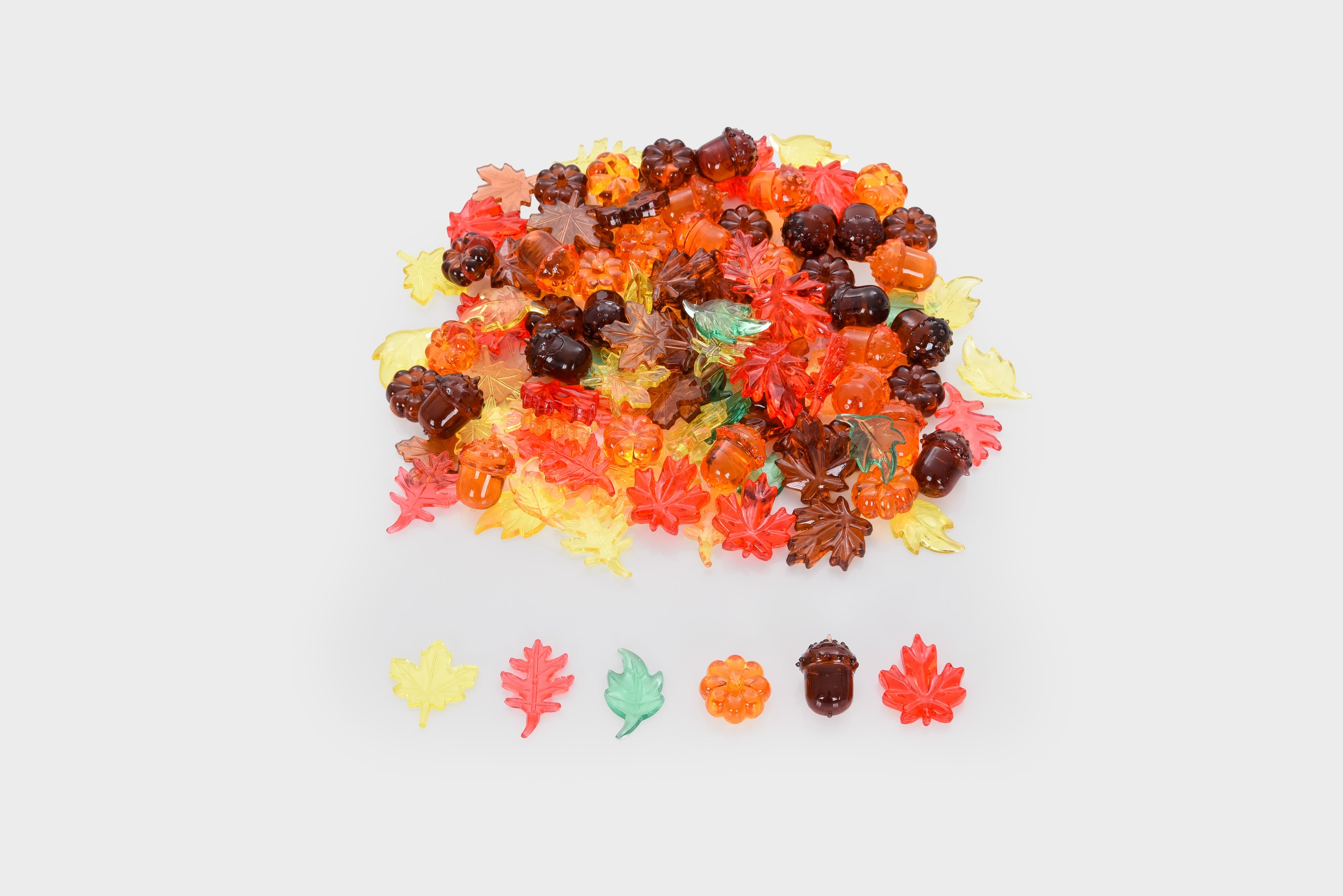 Translucent leaf and seed craft pieces in orange and yellow on a light base