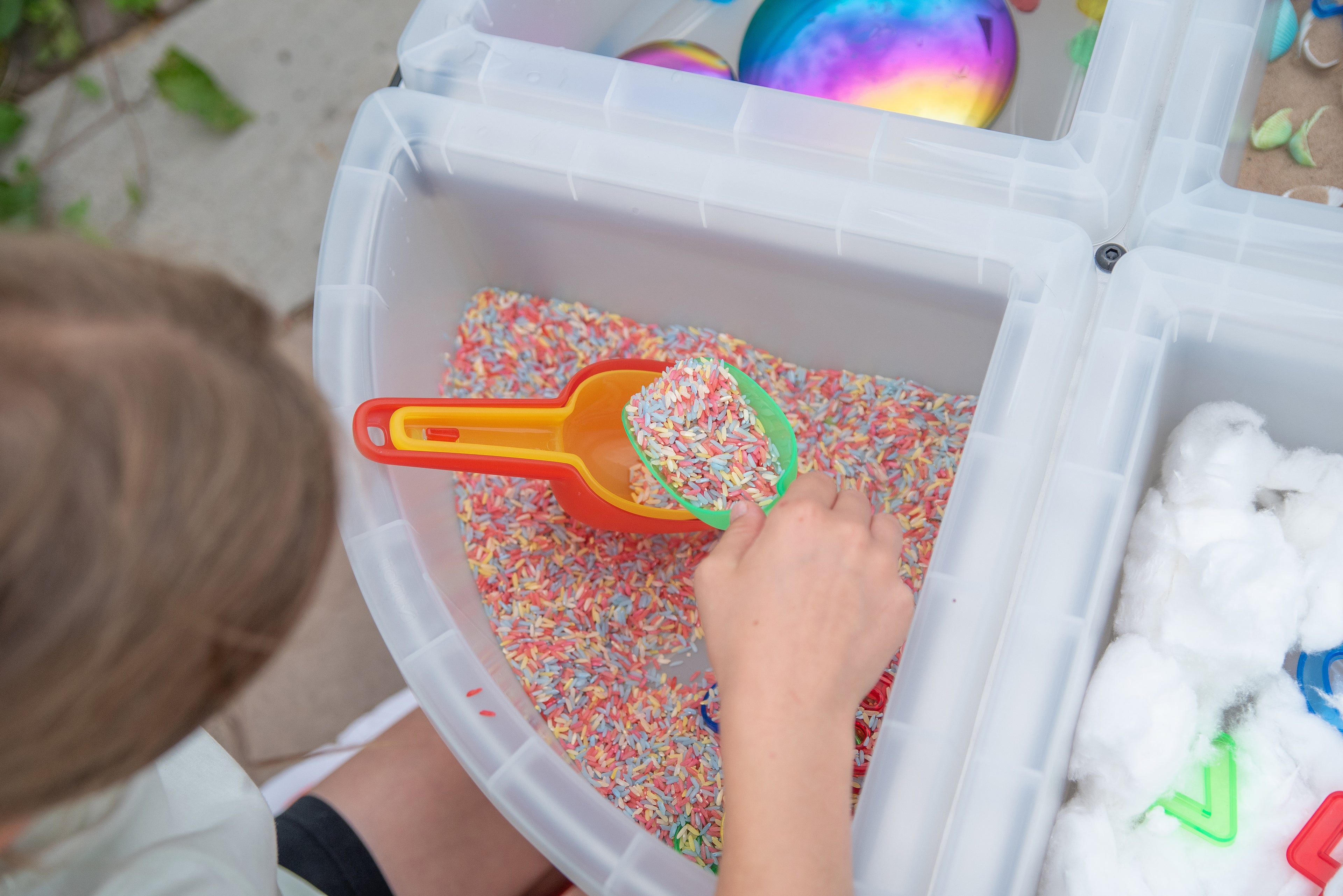Translucent nesting scoops in a clear bin, showing colorful scoop tops