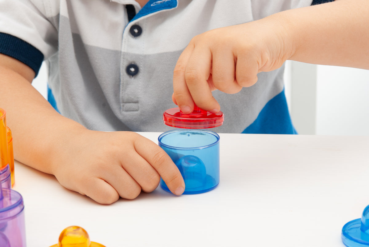 Translucent color pot with red snap lid and blue container, close-up