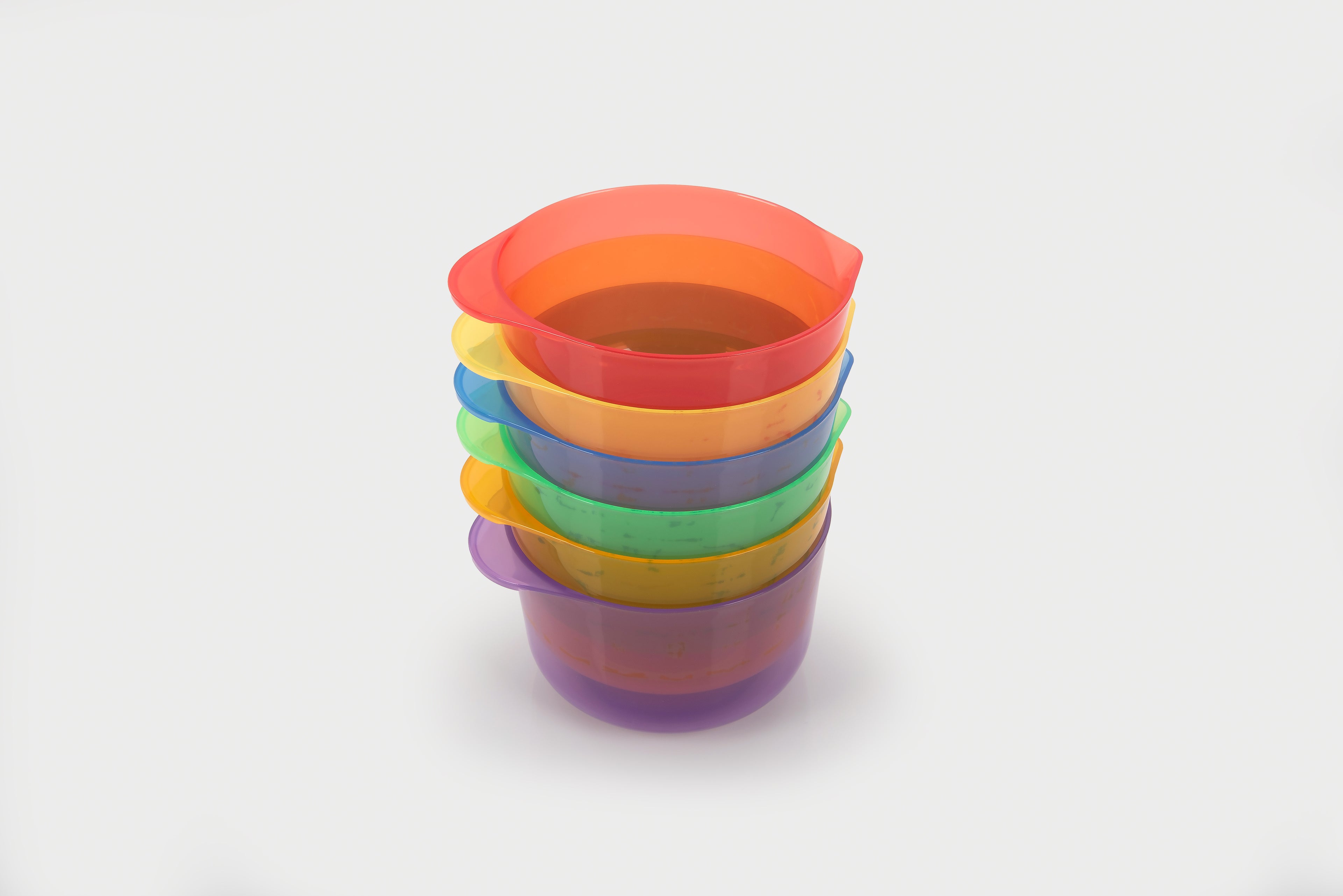 Stack of translucent pouring bowls in red, orange, purple, and blue tones