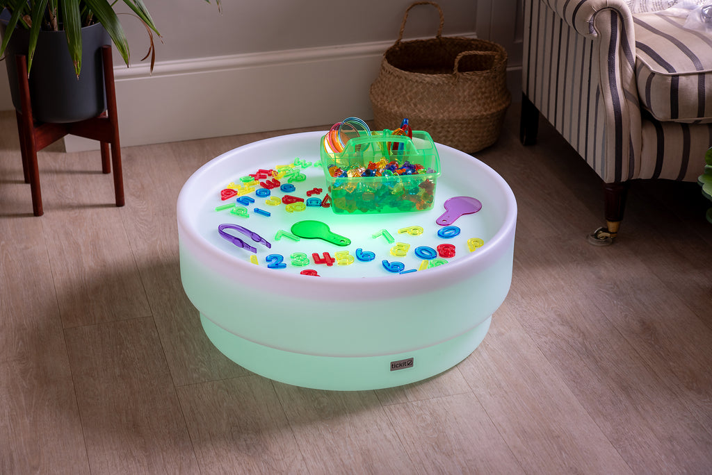 Translucent green bin and colorful number-letter pieces on a round light base