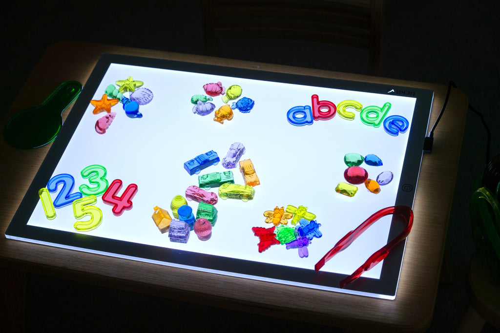 Colorful number and letter magnetic pieces on a light-up tablet