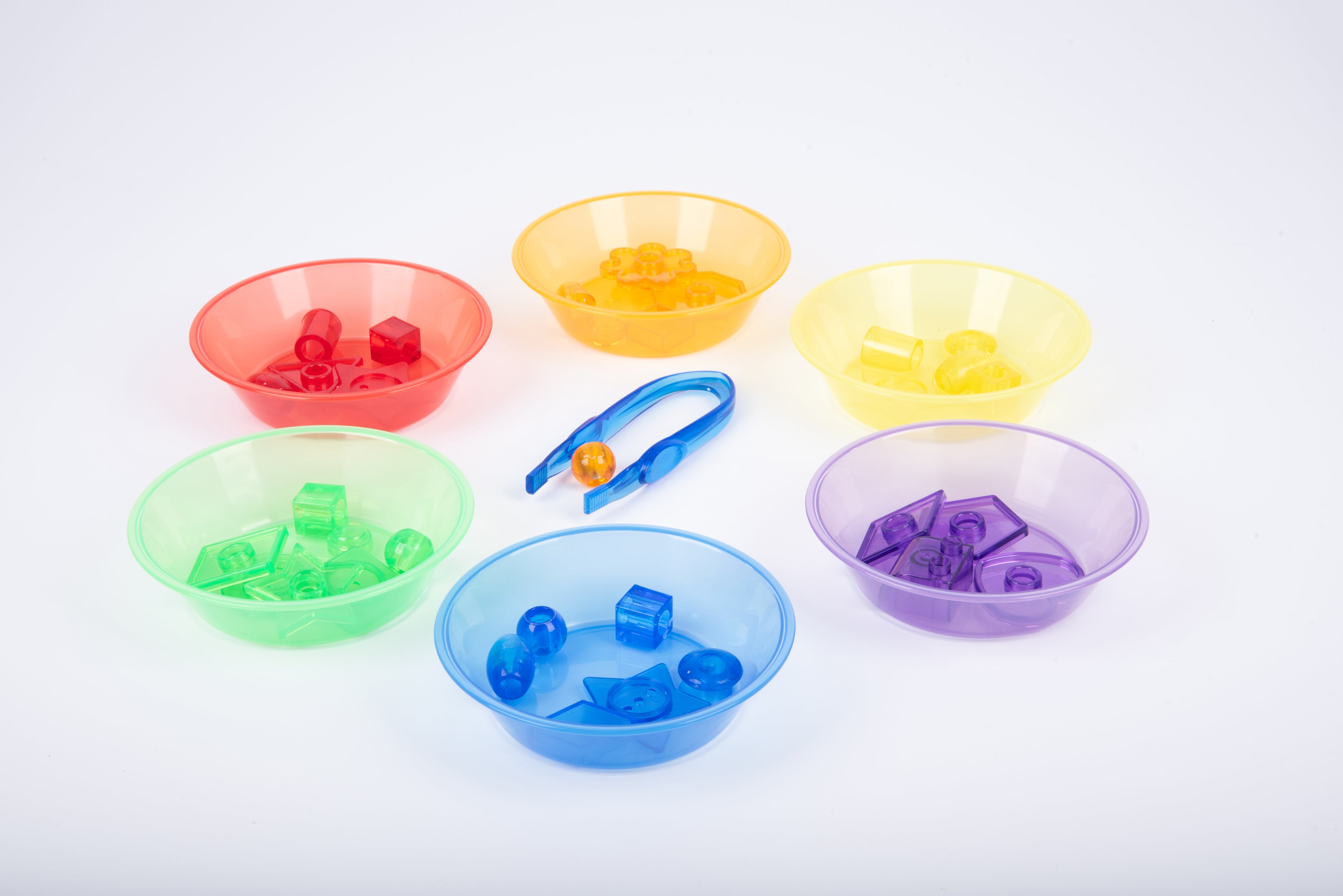 Translucent sorting bowls with colored pieces and a small blue grabbing tool