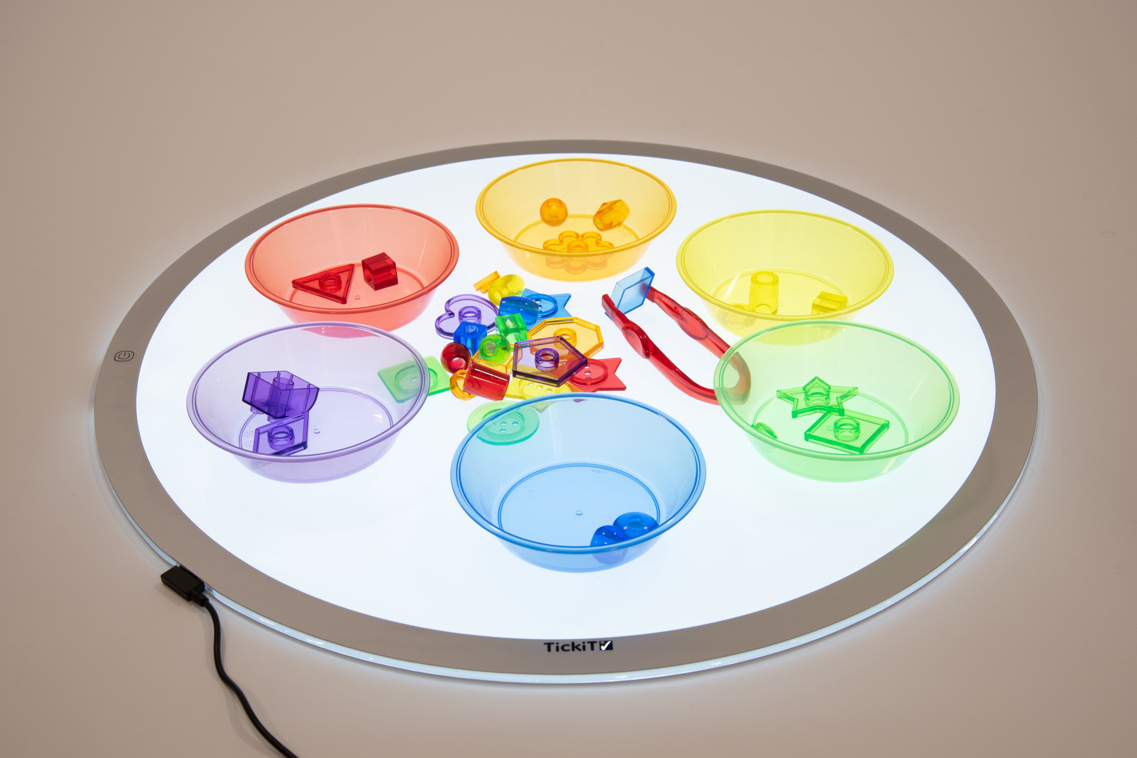 Translucent color sorting bowls arranged on a round platform with colorful pieces