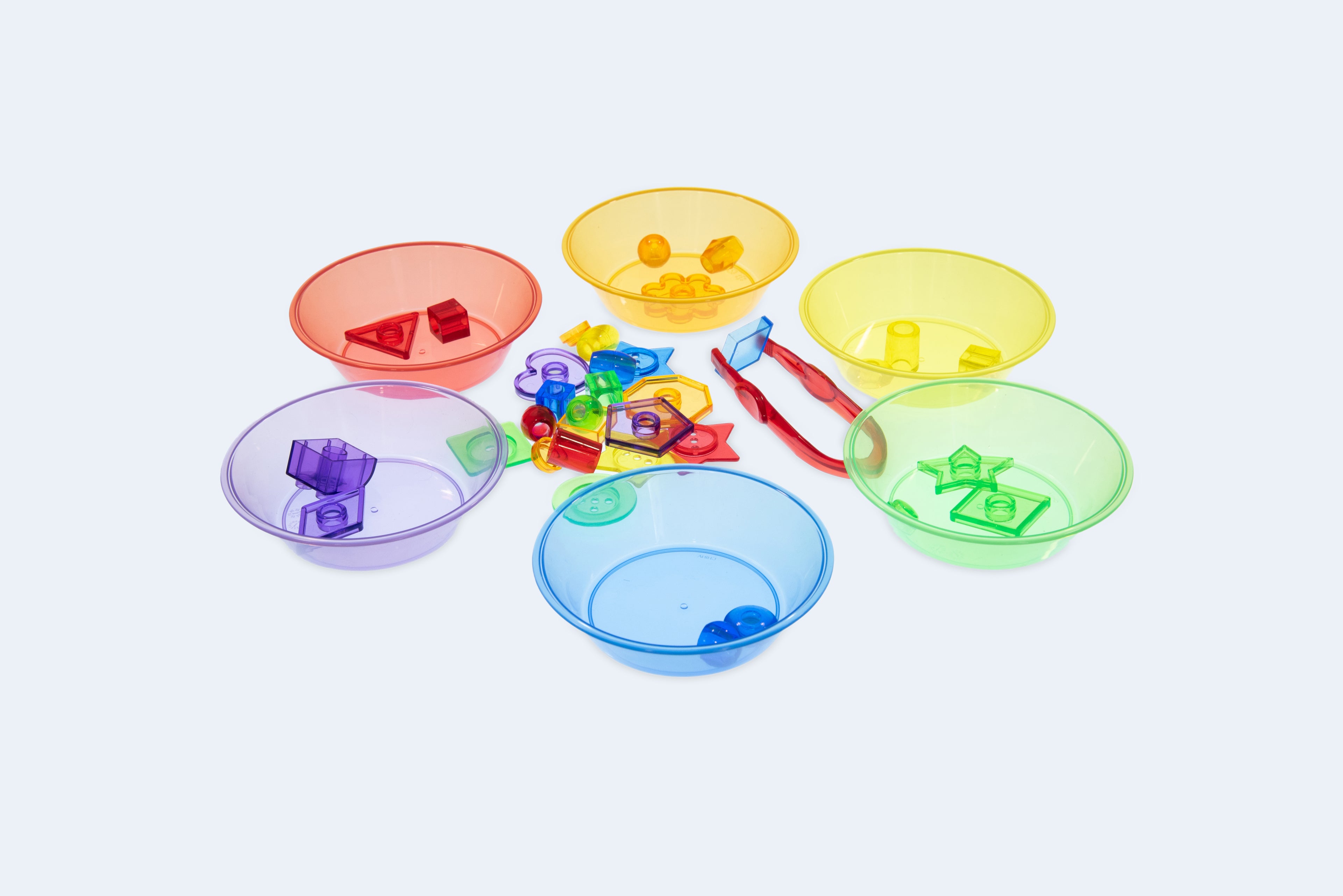 Set of translucent color sorting bowls in red, yellow, green, blue, and purple with pieces