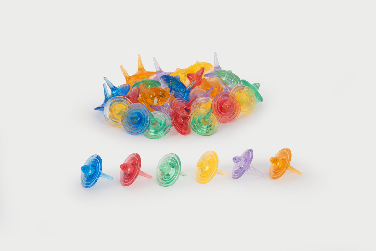 Translucent color spinners set with assorted colorful swirl tops, scattered on a surface